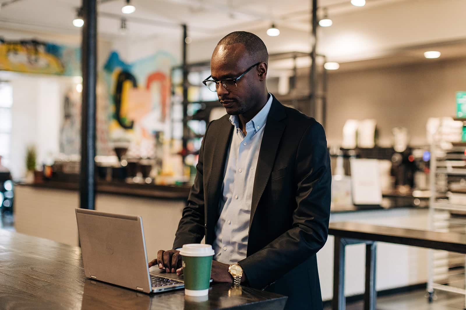 Man working on laptop in cafe